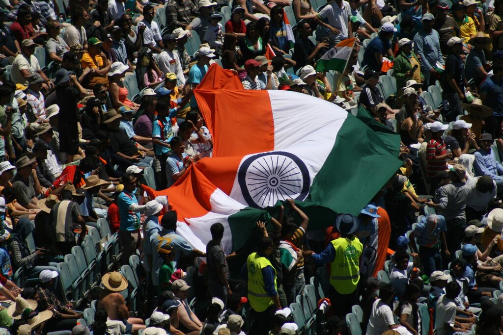 Cricket fans waving the Indian flag in the stands