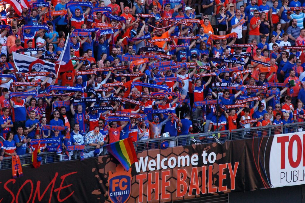 Football supporters holding up scarves in the fan stand